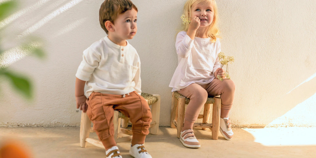 niño y niña sentados con sus zapatos muris y flores