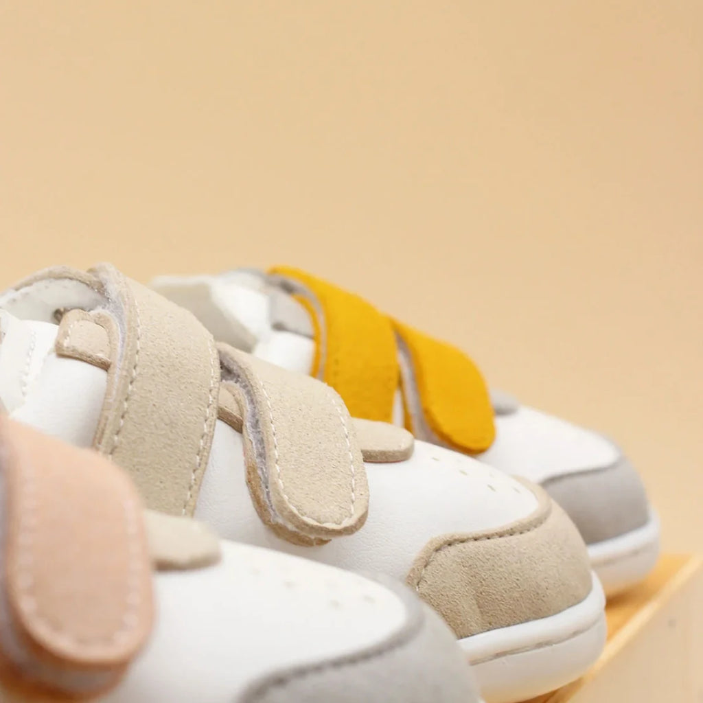 foto de estudio de un primer plano de tres zapatos modelo petra en color mostaza, beige y rosado