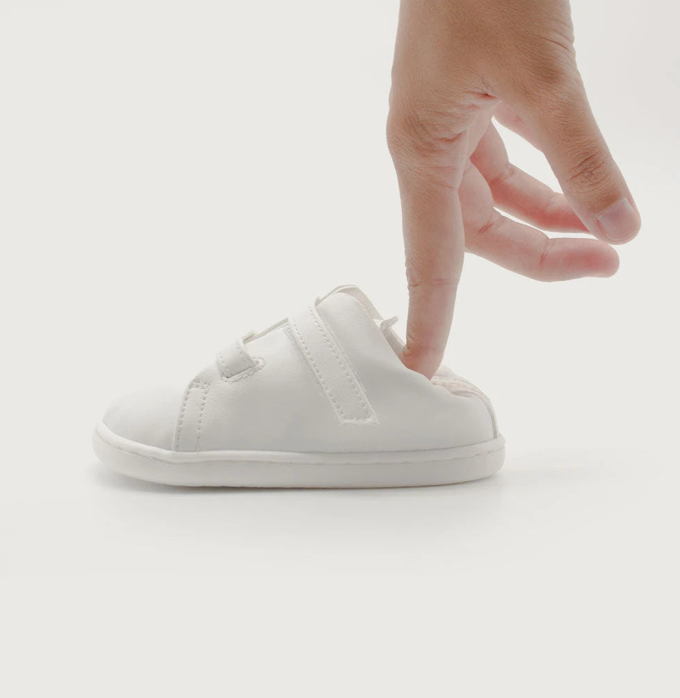 mano que manipula un zapato terre blanco para indicar que no hay contrafuerte